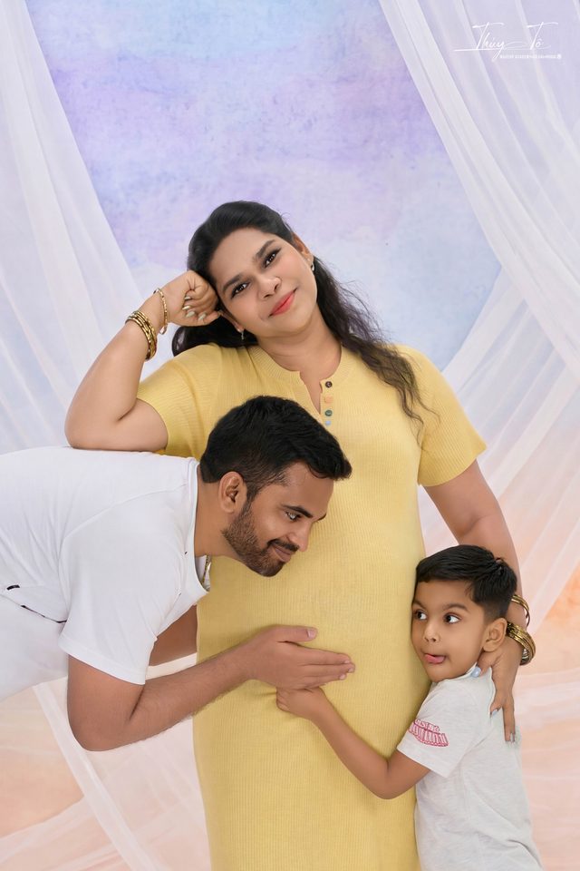 Ông xã áp tai vào bụng Mom, bé lớn đứng cạnh
