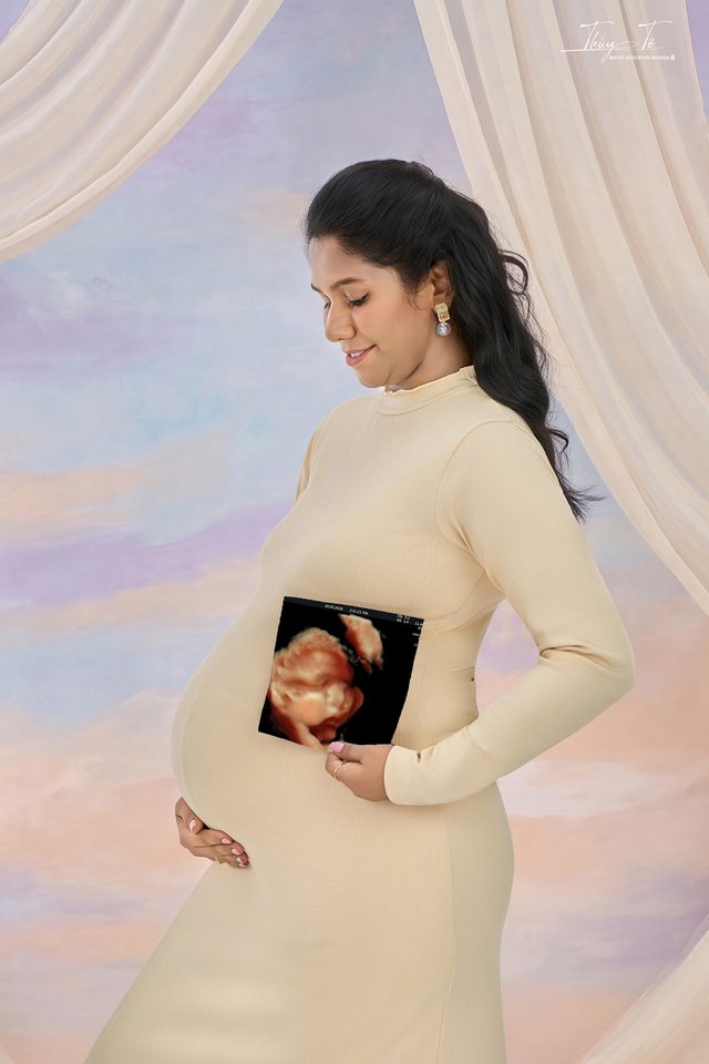 Mom váy be ôm dáng, cầm ảnh siêu âm