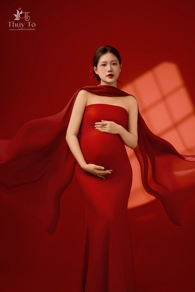 Mom trong concept lụa đỏ, nắng xiên qua rèm — Thúy Tô Studio