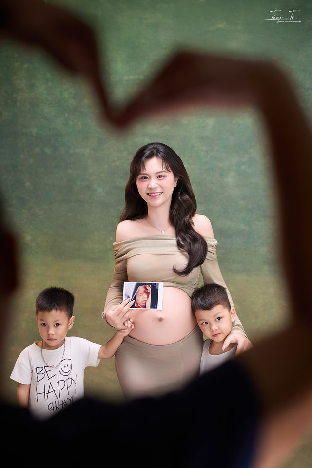 Hai bé trai chụm tay thành hình trái tim quanh Mom