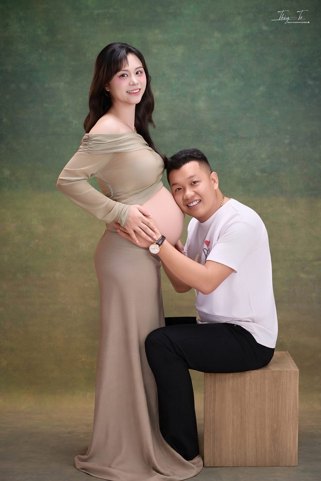 Ông xã quỳ bên Mom, tay đặt lên bụng