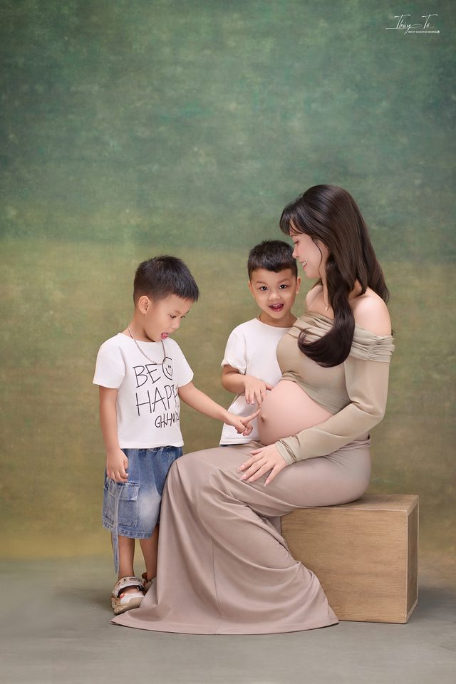 Hai bé trai áp tay vào bụng Mom