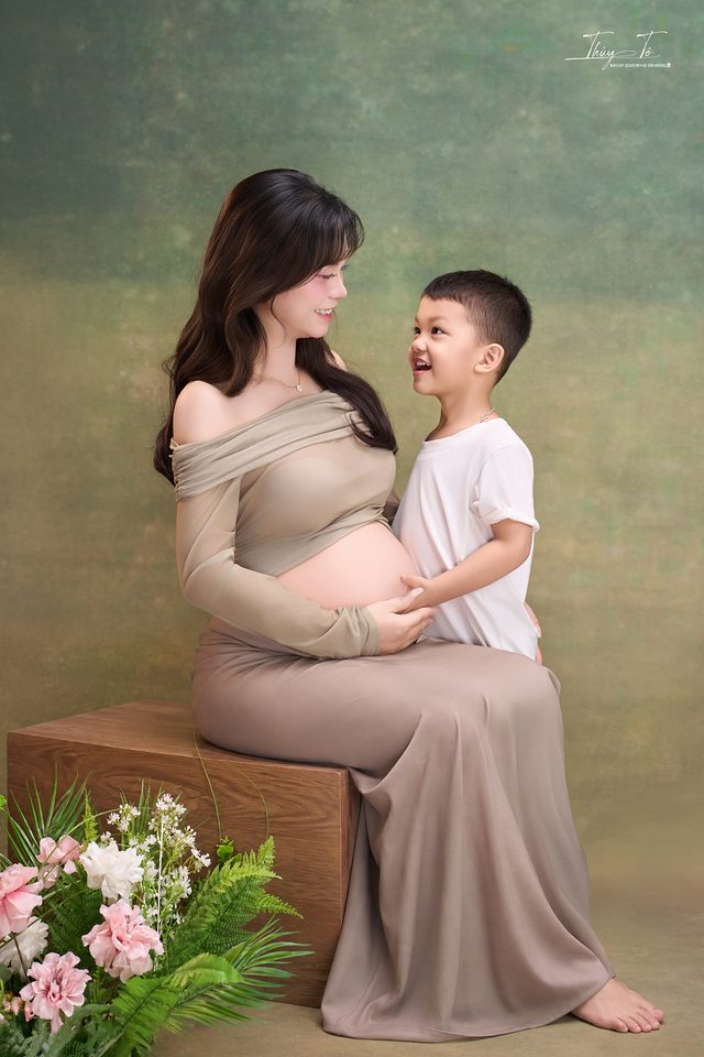 Mom ngồi cùng bé lớn, hoa tươi dưới chân